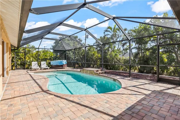 View of swimming pool featuring a patio and a lanai