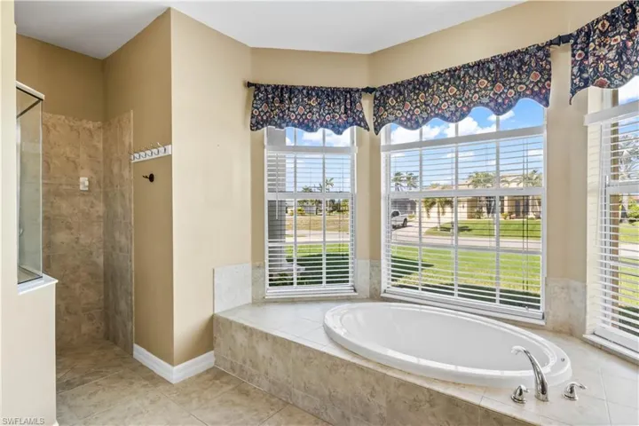 Bathroom featuring tile patterned floors, a healthy amount of sunlight, and shower with separate bathtub
