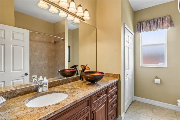 Bathroom featuring tile patterned floors, toilet, and vanity