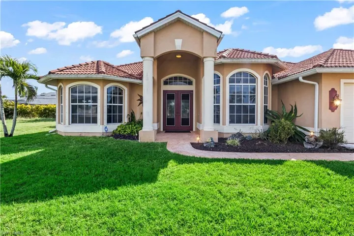 View of front of home with french doors, a garage, and a front yard