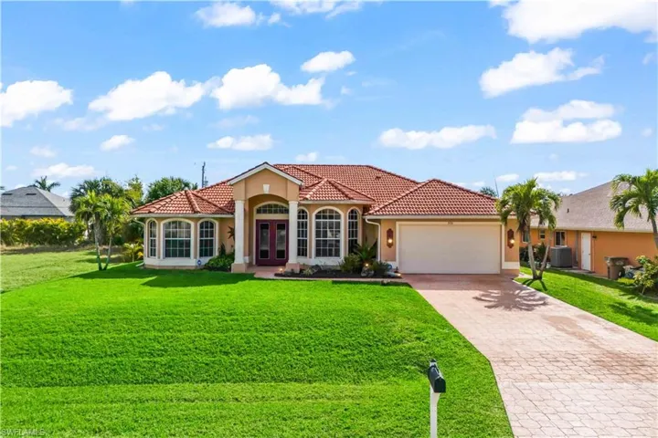 Mediterranean / spanish house featuring central AC, a garage, and a front lawn