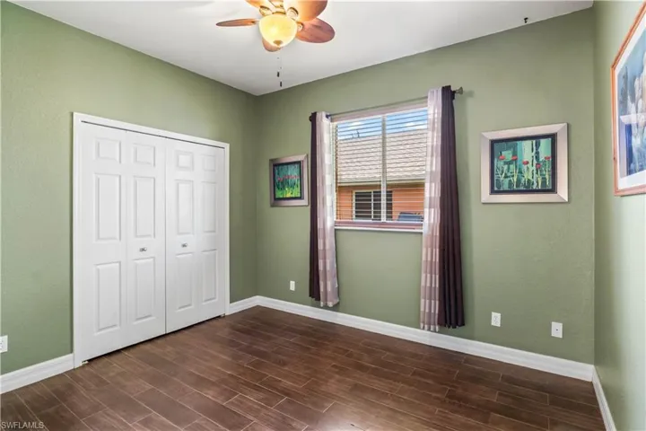 Unfurnished bedroom with dark wood-type flooring, a closet, and ceiling fan
