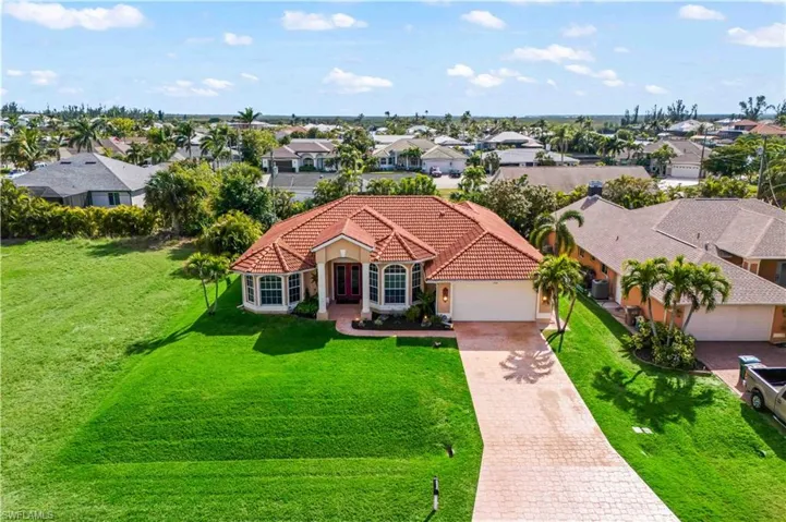 View of front of house with a garage and a front lawn
