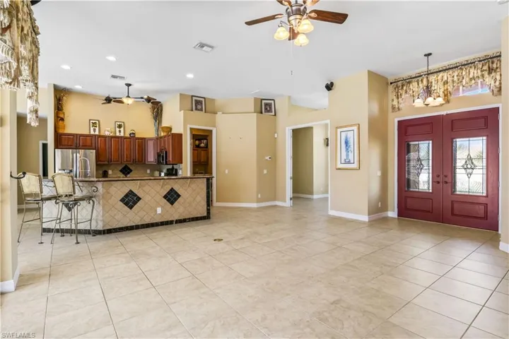 Tiled foyer entrance featuring french doors and ceiling fan