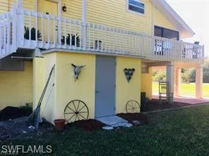SIDE of house featuring a yard and a balcony
