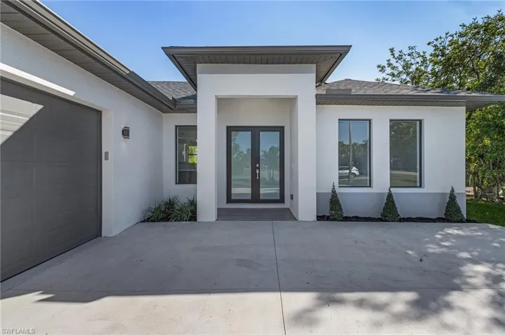 Doorway to property featuring french doors and a garage