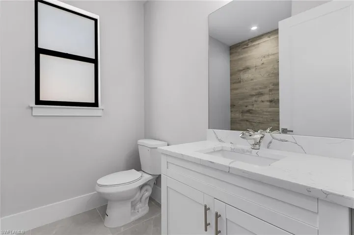 Bathroom featuring tile patterned flooring, vanity, and toilet