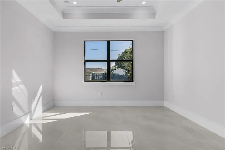 Unfurnished room with a tray ceiling and ornamental molding