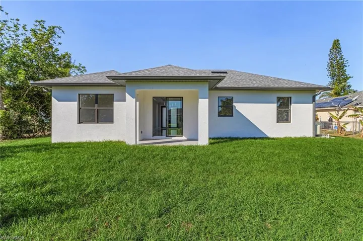 Back of property featuring a yard