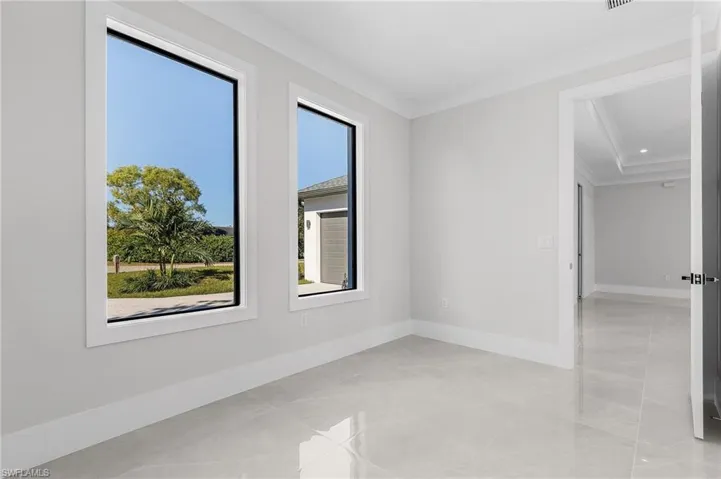 Spare room featuring a healthy amount of sunlight and ornamental molding