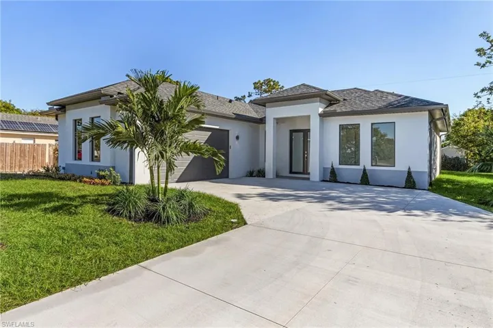View of front of house featuring a garage and a front lawn