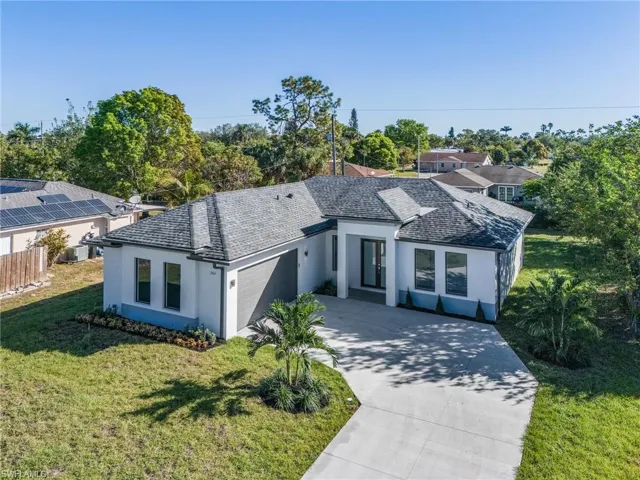 View of front of property featuring a garage and a front lawn