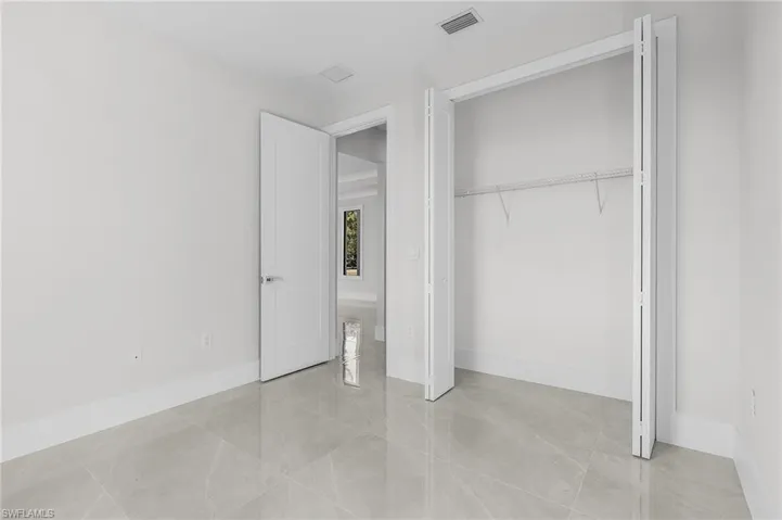 Unfurnished bedroom with light tile patterned flooring and a closet