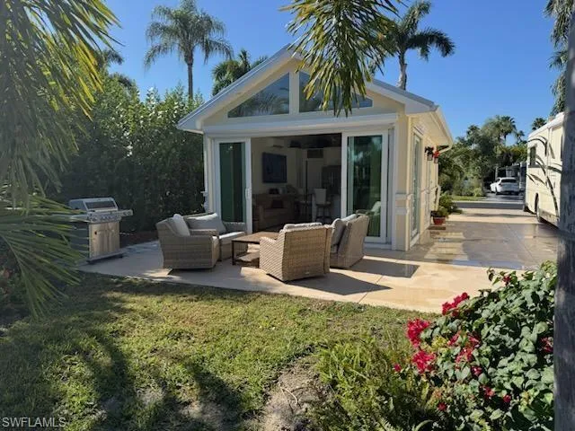 Rear view of house with an outdoor living space, an outdoor structure, and a patio area