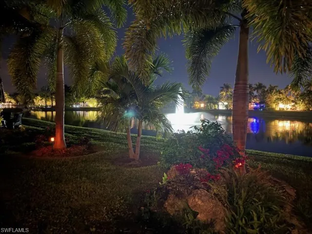 Yard at twilight featuring a water view