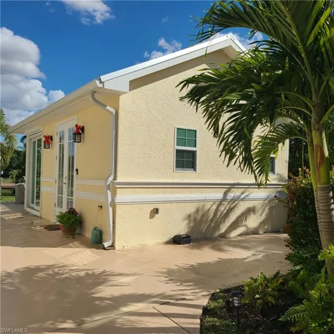 View of home's exterior with stucco siding and french doors