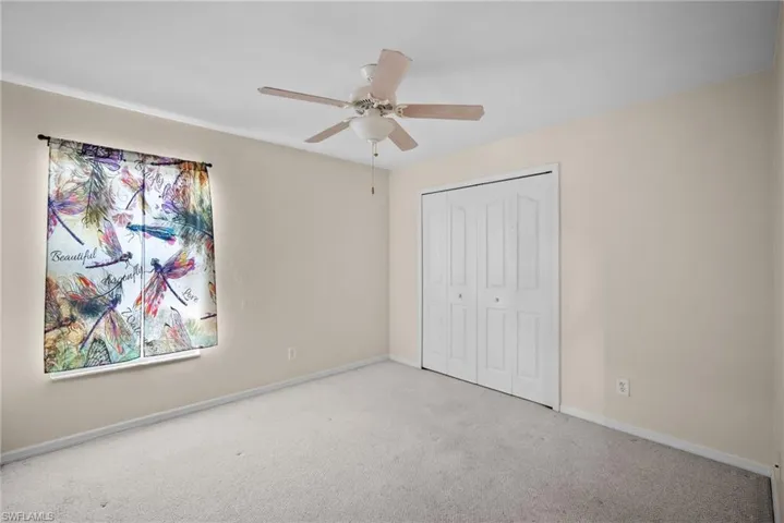 Unfurnished bedroom featuring carpet, ceiling fan, and a closet