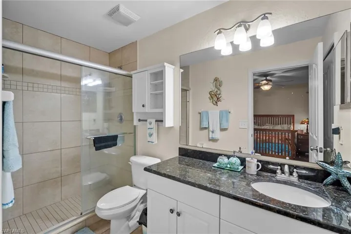 Bathroom featuring connected bathroom, vanity, and a shower stall