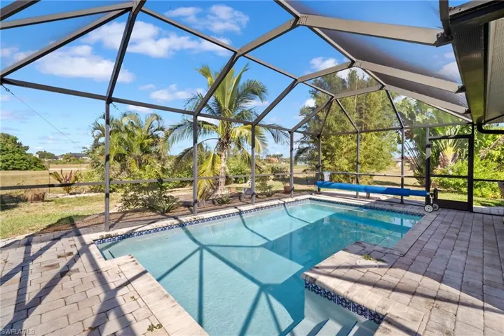 Swimming pool with a sunroom, a lanai, and a patio area