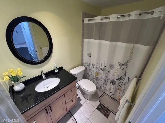 Full bath with vanity, a shower with curtain, and light tile patterned floors