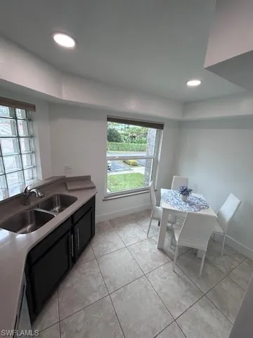 Kitchen with dark cabinets, recessed lighting, and light tile patterned floors