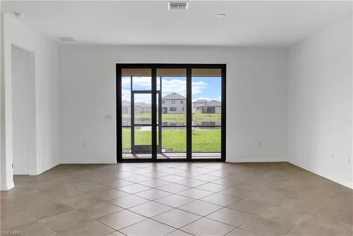 Empty room featuring light tile patterned floors and a residential view