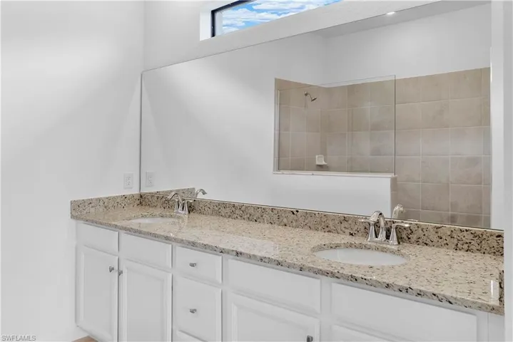 Bathroom featuring walk in shower and double vanity