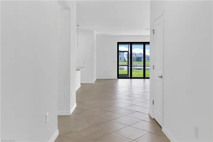 Hallway with baseboards and light tile patterned flooring