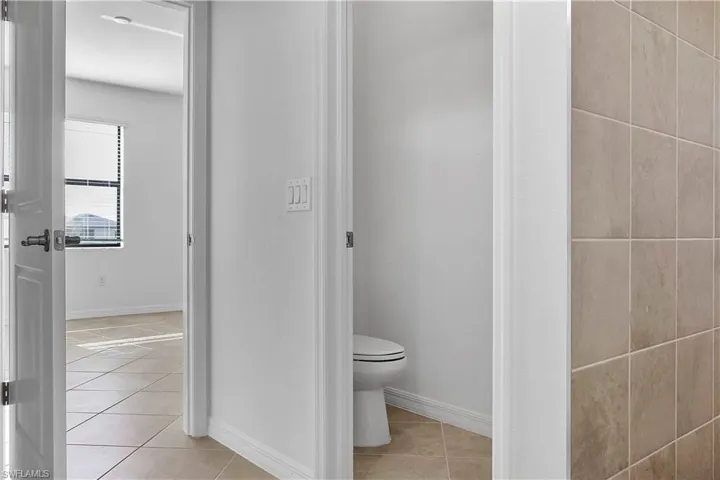 Bathroom featuring light tile patterned flooring and baseboards