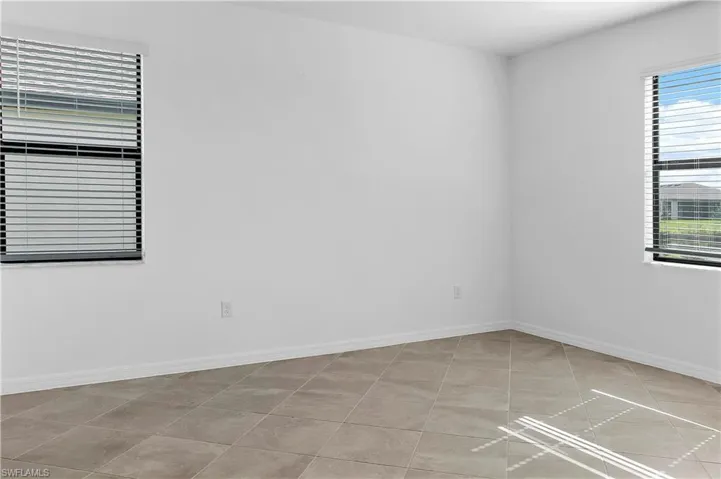 Empty room featuring baseboards and light tile patterned floors