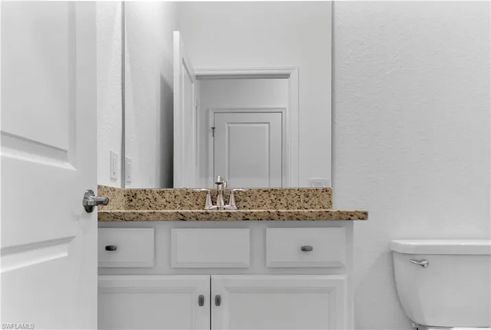Bathroom with a textured wall and vanity