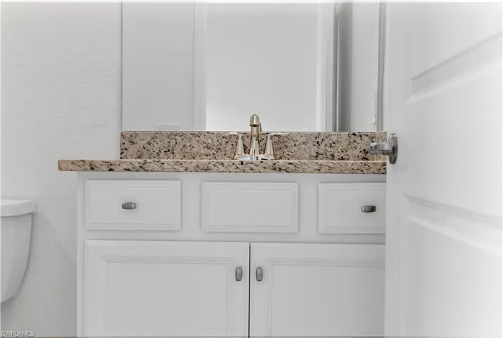 Bathroom view of vanity and a textured wall