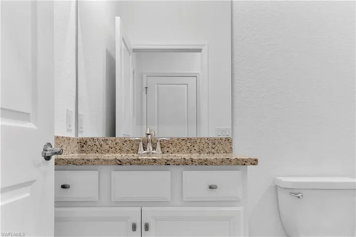 Bathroom with a textured wall and vanity