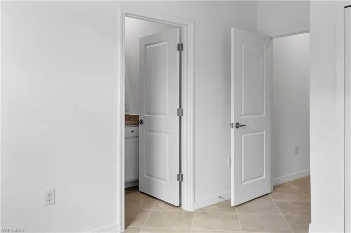 Corridor featuring baseboards and light tile patterned flooring