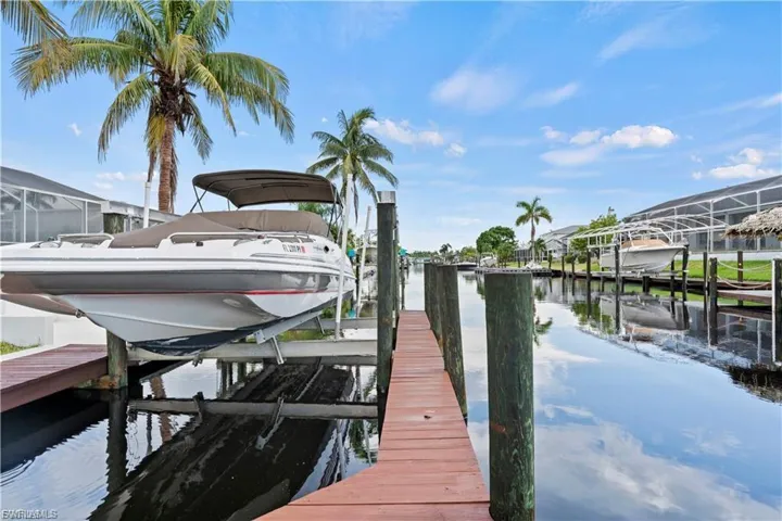 Dock featuring boat lift and a water view