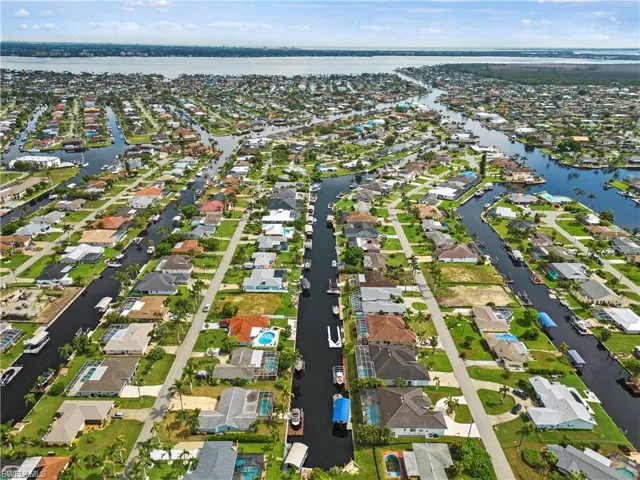 Aerial view of property and surrounding area with a nearby body of water and nearby suburban area