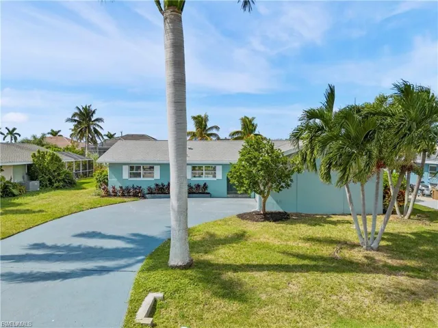 View of front of property with driveway and a front lawn