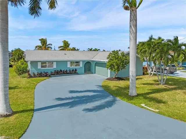 Single story home with concrete driveway, a front yard, a garage, and stucco siding