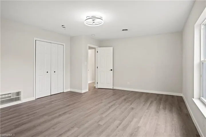Unfurnished bedroom featuring light wood-style flooring and a closet