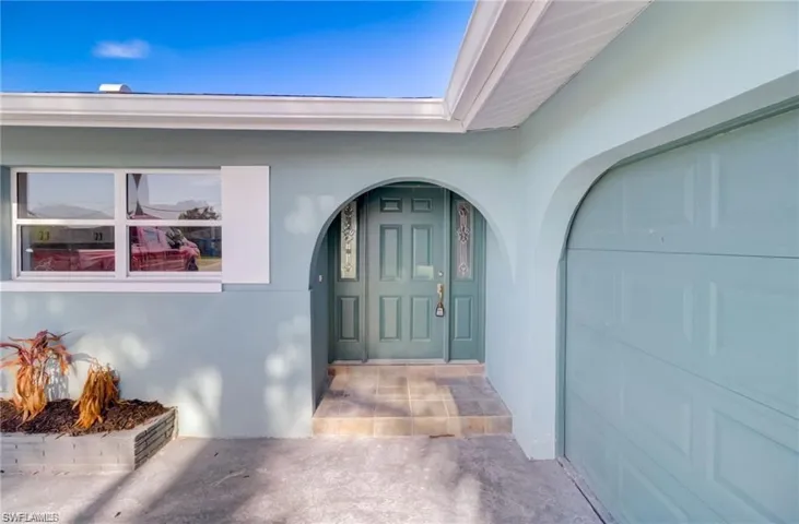 Property entrance featuring stucco siding and a garage