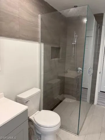 Full bath featuring vanity, a shower stall, and tile patterned flooring