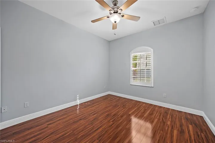 Bedroom with dark wood-style flooring and ceiling fan