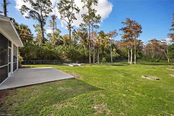 Fenced backyard featuring a patio and a sunroom