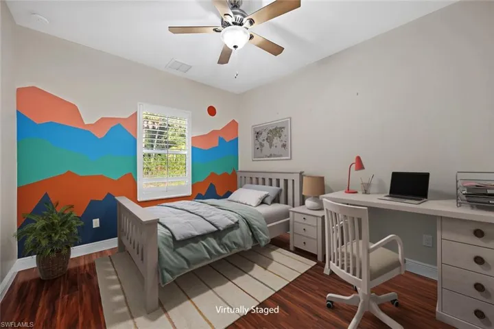 Bedroom with a desk, dark wood-style floors, and a ceiling fan