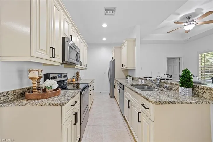 Kitchen featuring granite counters, stainless steel appliances a breakfast bar, and recessed lighting