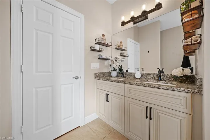Bathroom featuring double vanity and light tile patterned floors