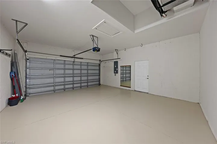 Garage featuring electric panel and a garage door opener