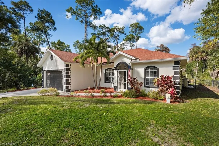 View of front of home with stucco siding, concrete driveway, an attached garage, and roof with shingles