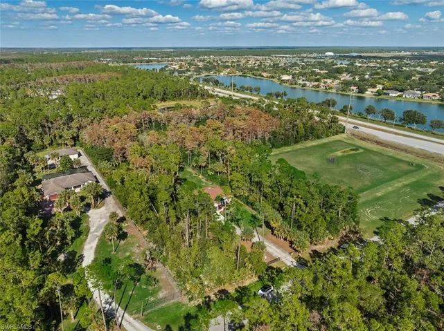 Aerial view of property and surrounding area with a nearby body of water