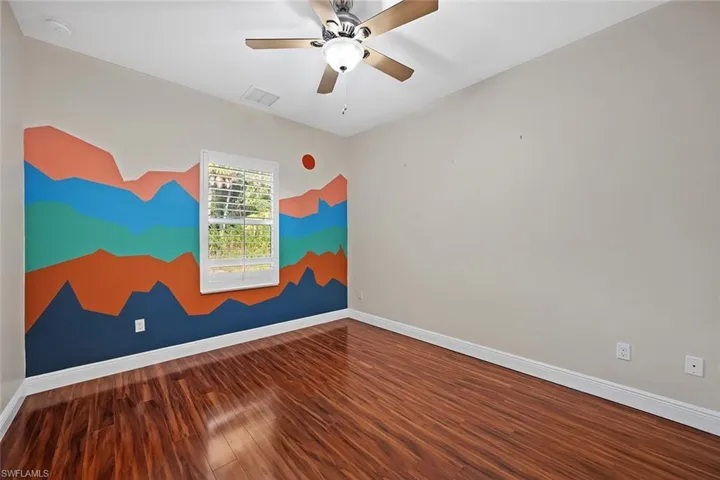 Bedroom featuring dark wood-style flooring and a ceiling fan